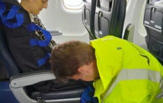 Passenger being assisted on an air plane.